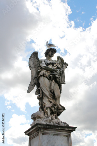 Angel Carrying the Scourge by Lazzaro Morelli at Castel Sant'Angelo and a seagull stand on top statue, Rome, Italy © Crystaltmc