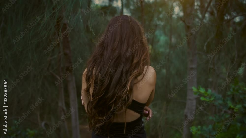 Fit girl enjoys walking through the pine trees forest at sunset hike Fit girl enjoys walking through the pine trees forest at sunset hike