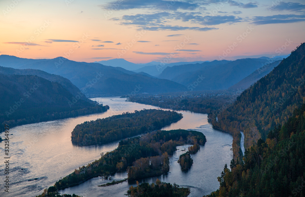 The Yenisei River flows through a picturesque valley. Sunrise in the mountains. South of Western Siberia.