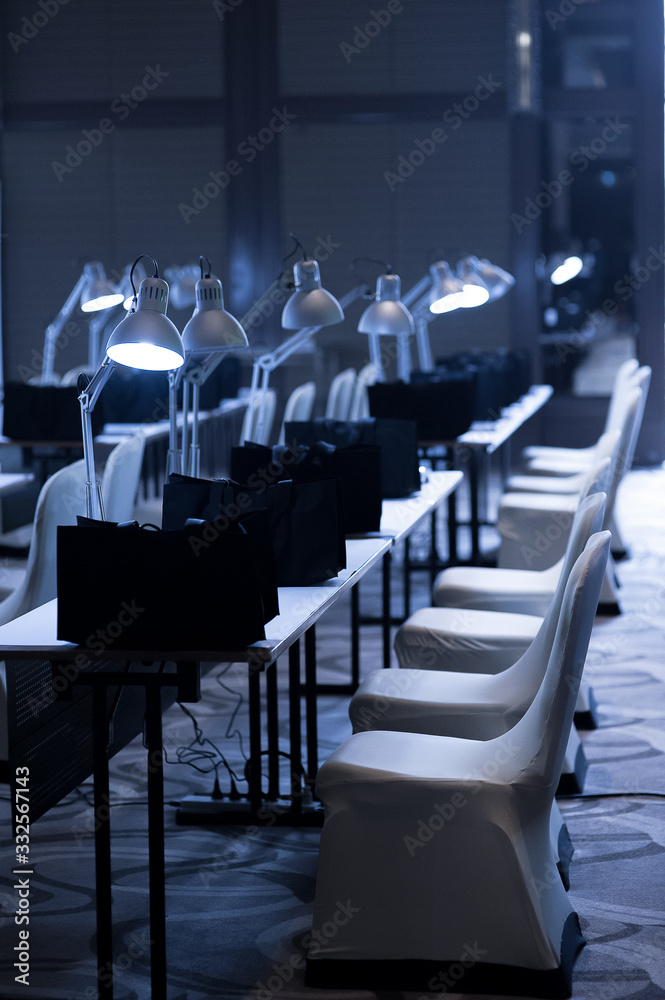 Naklejka premium desk lamps in the row on tables with empty chairs