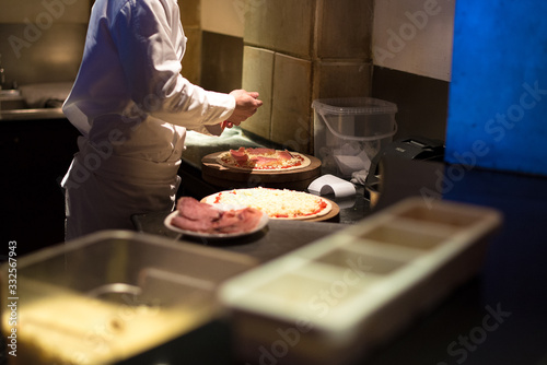 Chef making pizza in kitchen