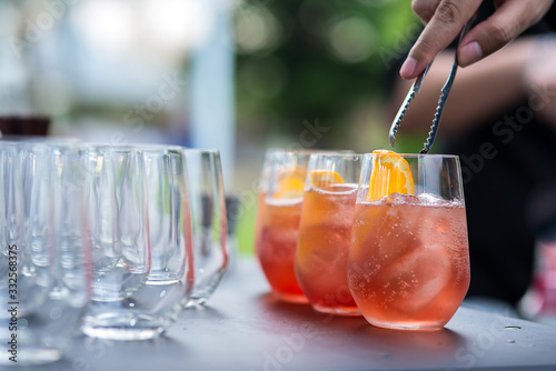 Bartender pouring cocktail in glasses