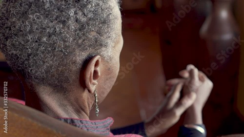 Old African American woman rubbing her thumb joint to relieve arthritis pain
