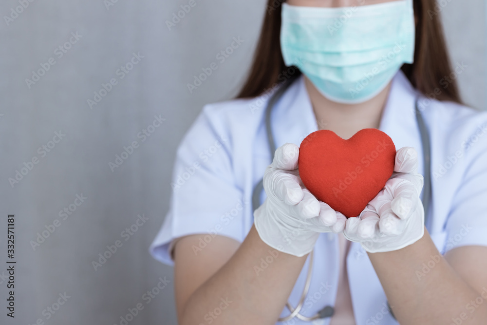 Woman doctor in white uniform holding red heart . Cardio Therapist, doctor makes cardiac physical. Woman doctor in white uniform holding red heart . Cardio Therapist, doctor makes cardiac physical.