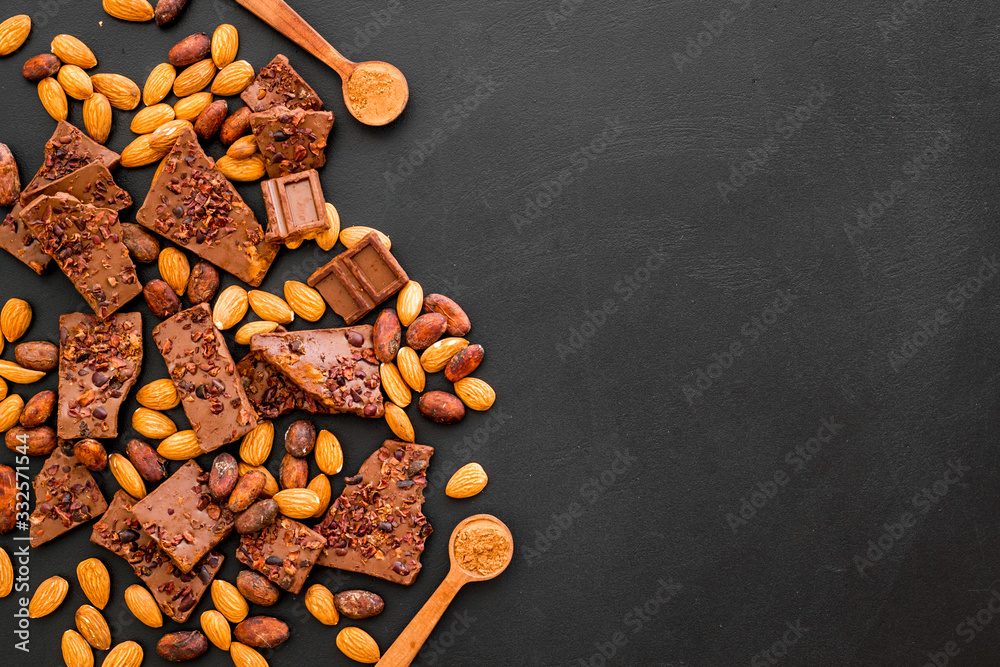 Chocolate frame. Broken slices and nuts on black background top-down copy space Chocolate frame. Broken slices and nuts on black background top-down copy space
