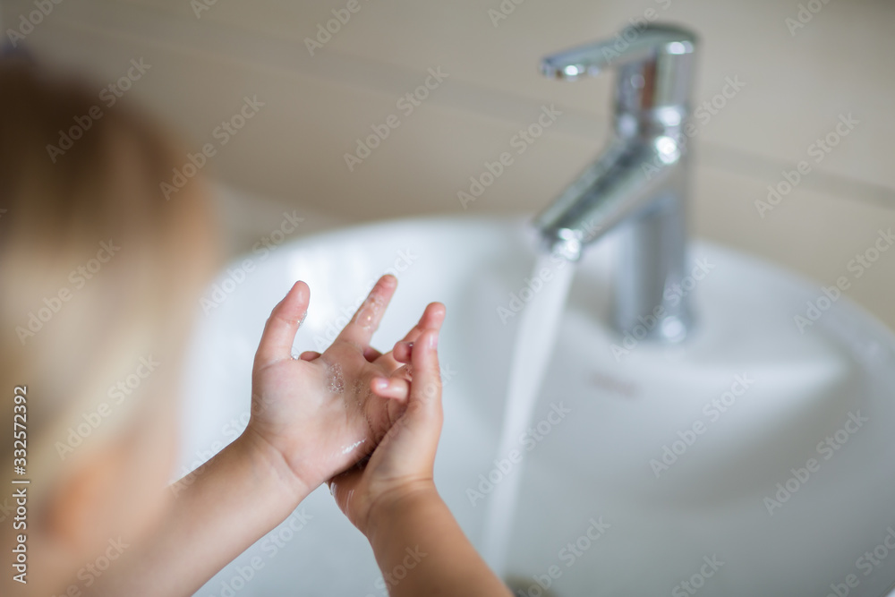 Naklejka premium Hygiene concept. Kid Washing hands with soap under the faucet with water. Hygiene to stop spreading coronavirus.