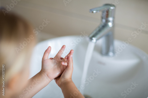 Hygiene concept. Kid Washing hands with soap under the faucet with water. Hygiene to stop spreading coronavirus.