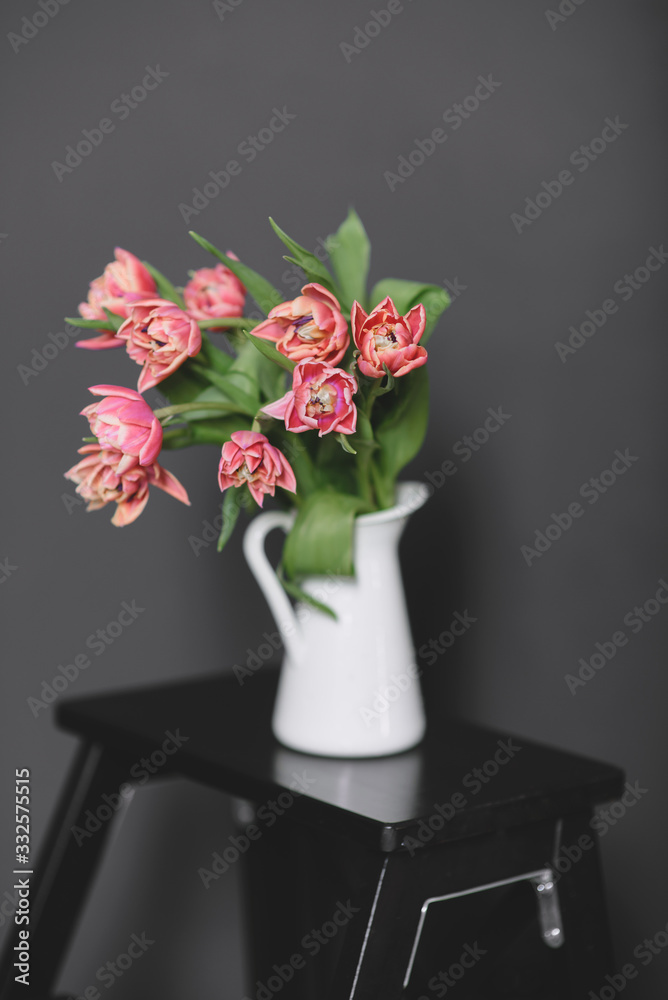 Fototapeta premium A bouquet of pink peony tulips in a white jug.