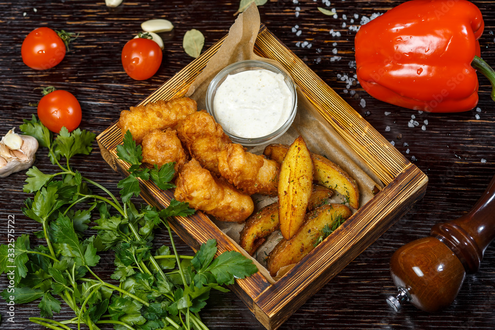 Breaded chicken fillet with fried potatoes and white sauce. Parsley, tomatoes, bell pepper and spices. Breaded chicken fillet with fried potatoes and white sauce. Parsley, tomatoes, bell pepper and spices.
