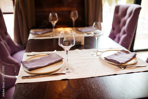 Served table in restaurant with wine glasses and purple accents
