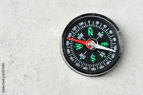 compass with a red magnetic arrow on a gray background with space for text
