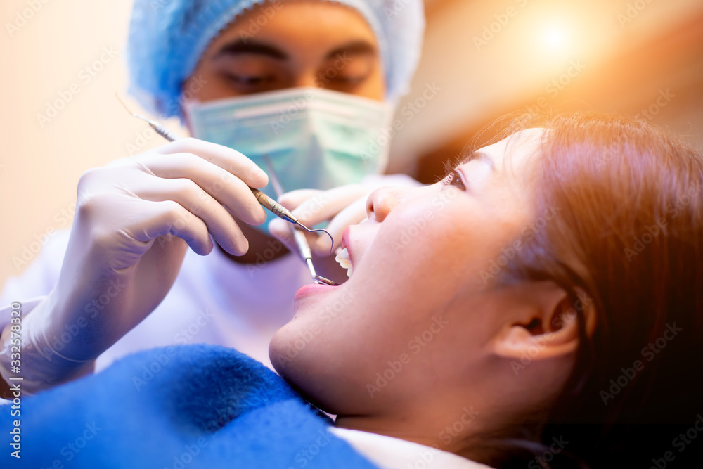 Dentists examining patients lying in chair in a dental clinic. Dentists examining patients lying in chair in a dental clinic.