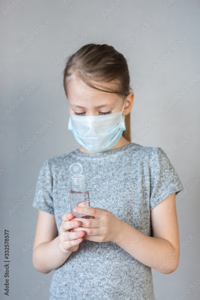 Close- up view of a little girl using a small portable antibacterial hand sanitizer. hand sanitizer gel for hand hygiene spread protection.