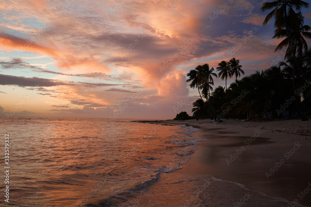 Sunset on the beach. Paradise beach. Tropical paradise, white sand, beach, palm trees and clear water.