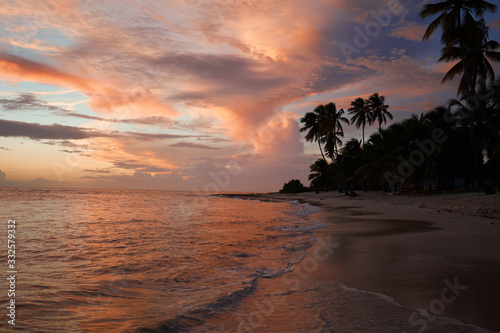 Sunset on the beach. Paradise beach. Tropical paradise  white sand  beach  palm trees and clear water.