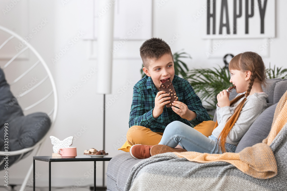 Cute little children eating chocolate at home Cute little children eating chocolate at home