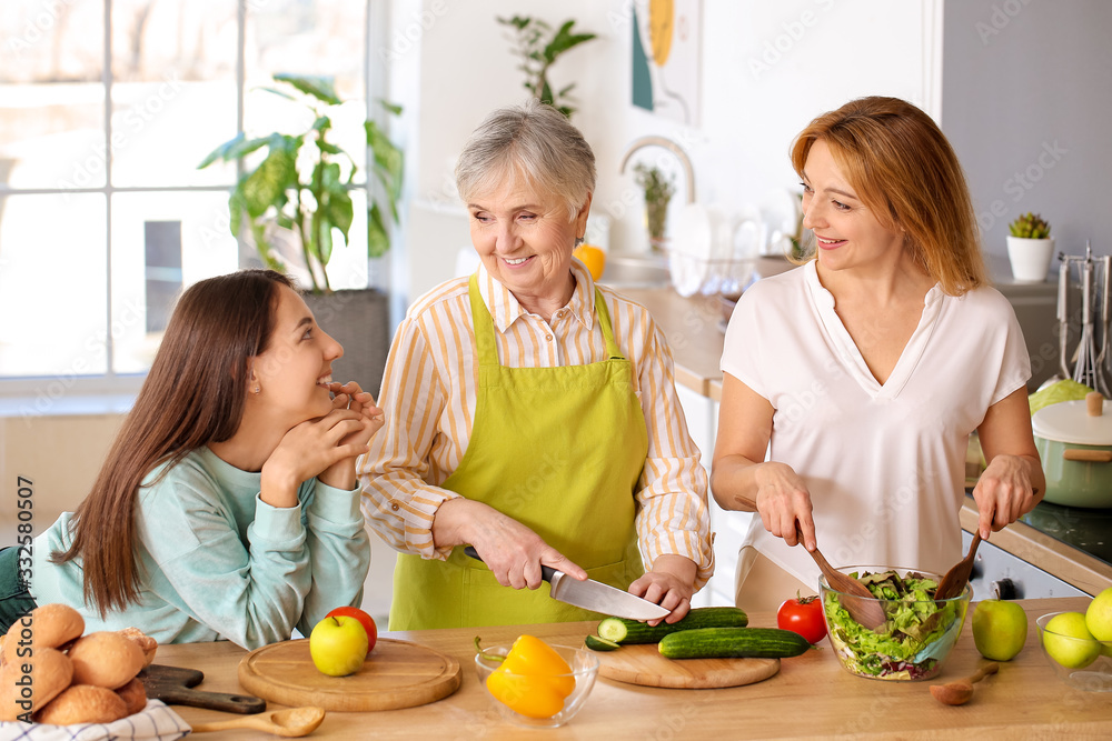 Mature woman with her adult daughter and mother cooking together at home