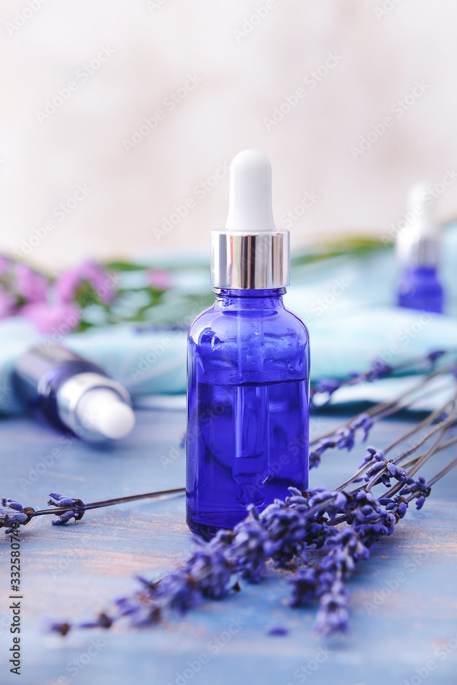 Bottle with lavender essential oil on table Bottle with lavender essential oil on table