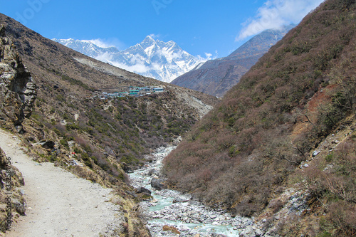 Everest and Lhotse mountain peaks rises above mountain valley with Imja Khola river in Himalayas during the day on the way to Everest base camp in Nepal. Theme of beautiful mountain landscapes. photo