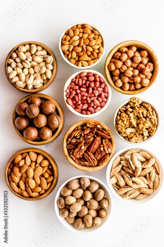 Set of macadamia, hazelnut, walnut, almond, pistachio, pecans nuts on white background top-down pattern