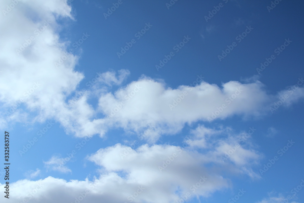 White clouds on a blue sky. Background for text and design White clouds on a blue sky. Background for text and design