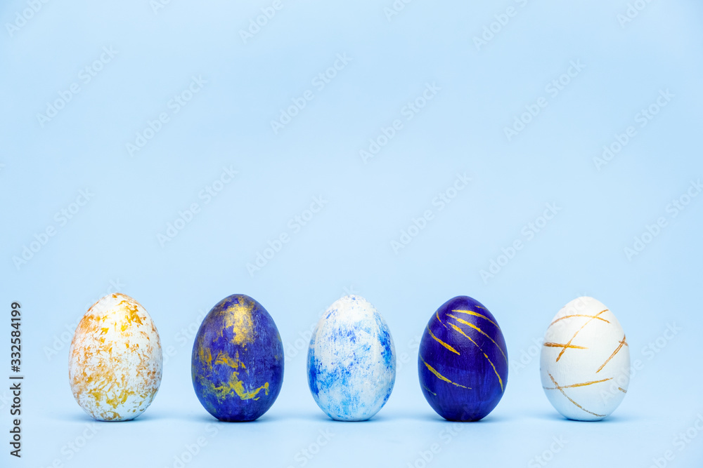 Three easter trendy colored classic blue and golden decorated eggs on blue background. Happy Easter card with copy space for text. Minimal easter style. Three easter trendy colored classic blue and golden decorated eggs on blue background. Happy Easter card with copy space for text. Minimal easter style.