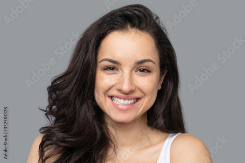 Pretty brunette girl with long hair smiling widely