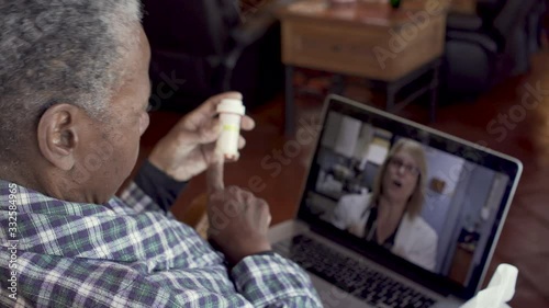 Sick elderly black woman talking to her female doctor about her medication