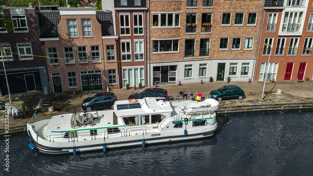 Aerial view of houseboat in canal in typical Dutch town, cruise boat vacation in Netherlands