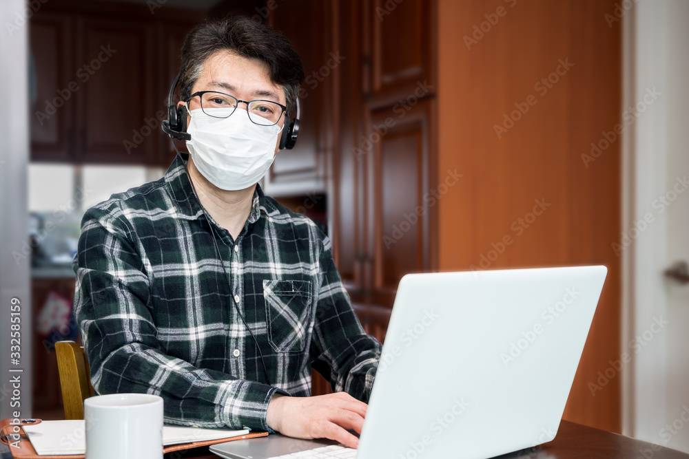 An Asian man who is self-isolated and working from home because of a massive pandemic. An Asian man who is self-isolated and working from home because of a massive pandemic.