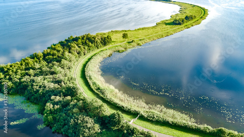 Aerial drone view of path on dam in polder water from above, landscape and nature of North Holland, Netherlands photo