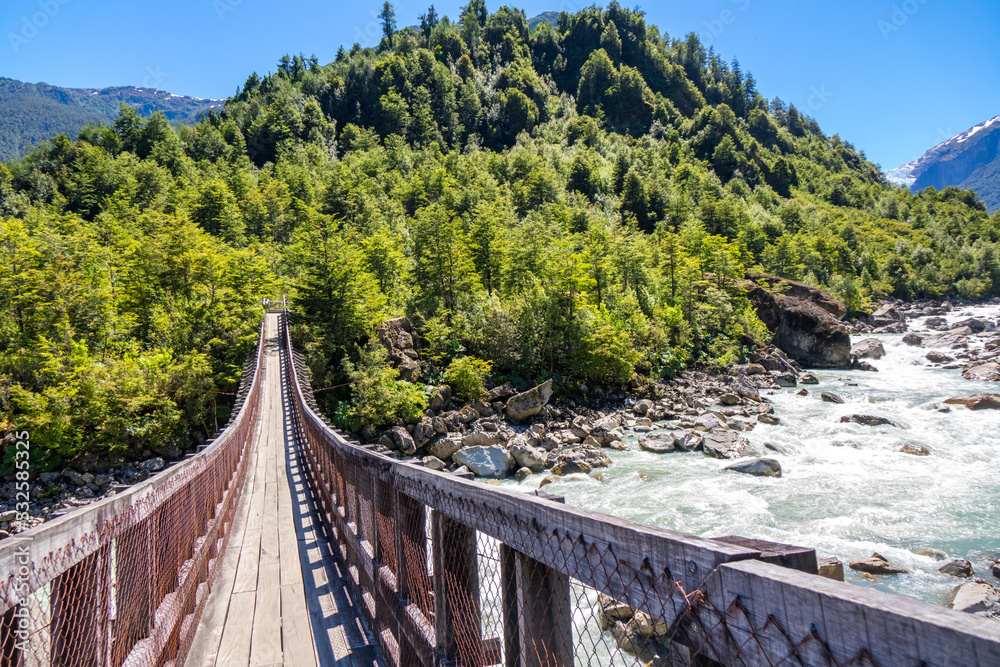 Fototapeta premium Wooden bridge across river Murta, landscape with beautiful mountains view, Patagonia, Chile, South America