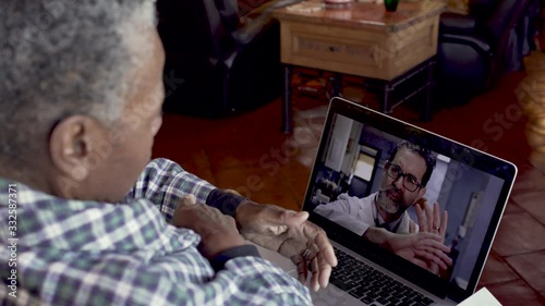 Elderly senior black woman identifying her wrist pain talking with her doctor