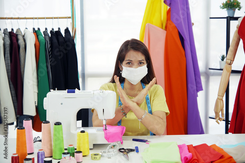 senior woman designer wear mask while she is working in workplace to protect corona virus