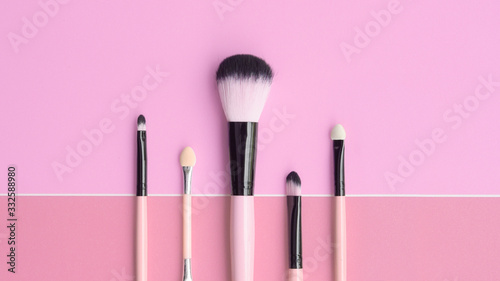 Set of makeup brushes on pink background                               