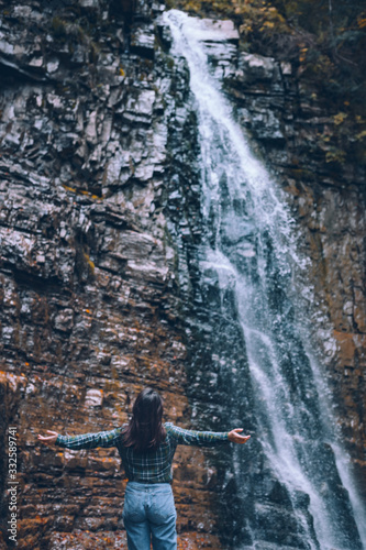 woman in casual clothes looking at waterfall