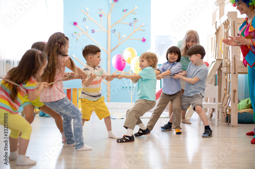 Group of children in a rope-pulling contest in kindergarten