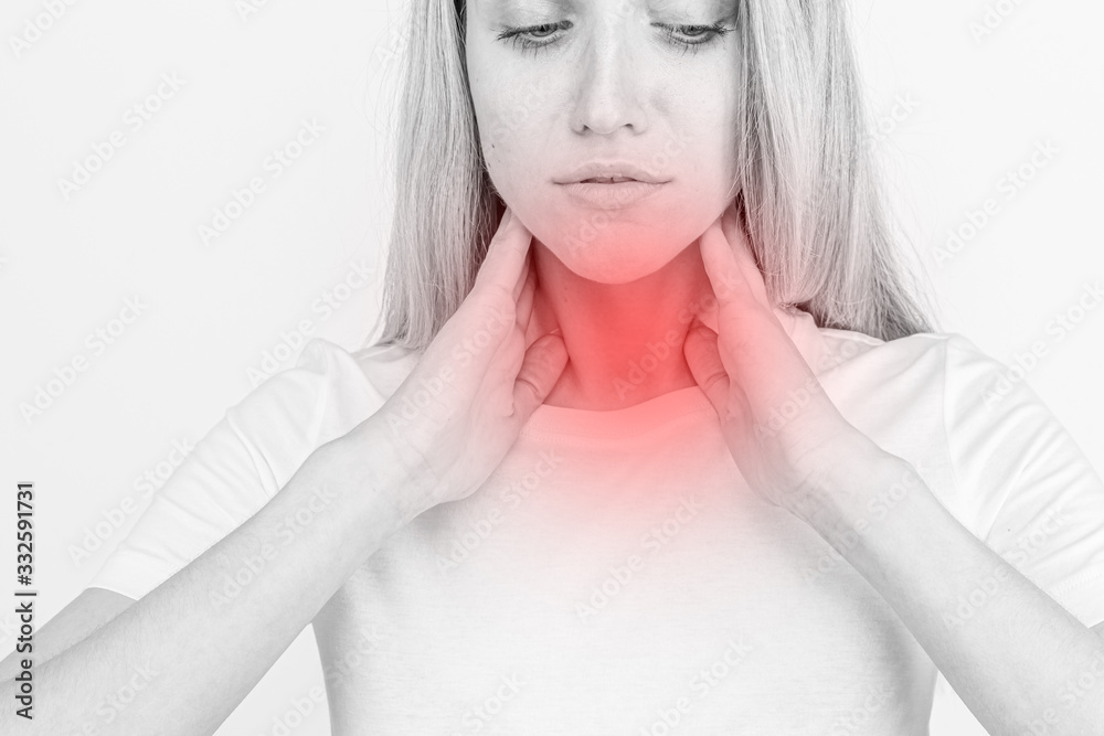Female checking thyroid gland by herself. Close up of woman in white t- shirt touching neck with red spot. Thyroid disorder includes goiter, hyperthyroid, hypothyroid, tumor or cancer. Health care Female checking thyroid gland by herself. Close up of woman in white t- shirt touching neck with red spot. Thyroid disorder includes goiter, hyperthyroid, hypothyroid, tumor or cancer. Health care