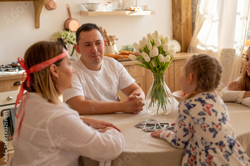 horizontal photo of a cheerful european family on the background of the kitchen interior