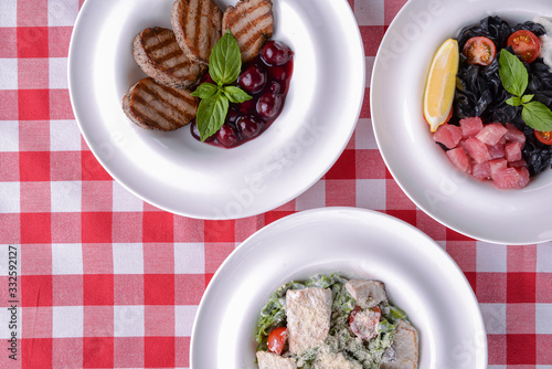 Wallpaper Mural Grilled meat pieces with sauce, pasta with pesto, black pasta with salmon fish and lemon. Torontodigital.ca