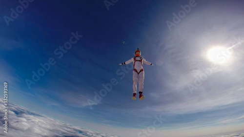 Investment. Parachutist performs an acrobatic trick in the air. Flying men make professional jump. Extreme as a hobby. 