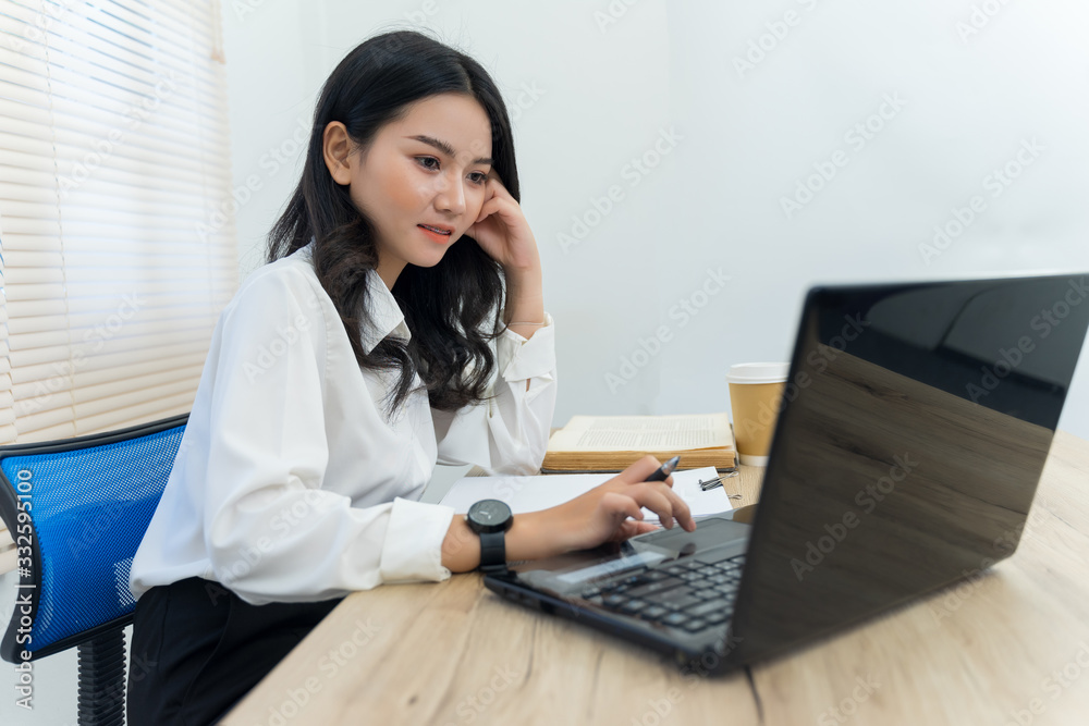 Young cheerful Asian female university student studying in self study room in the university library to do her assignment and prepare for examination. Young cheerful Asian female university student studying in self study room in the university library to do her assignment and prepare for examination.