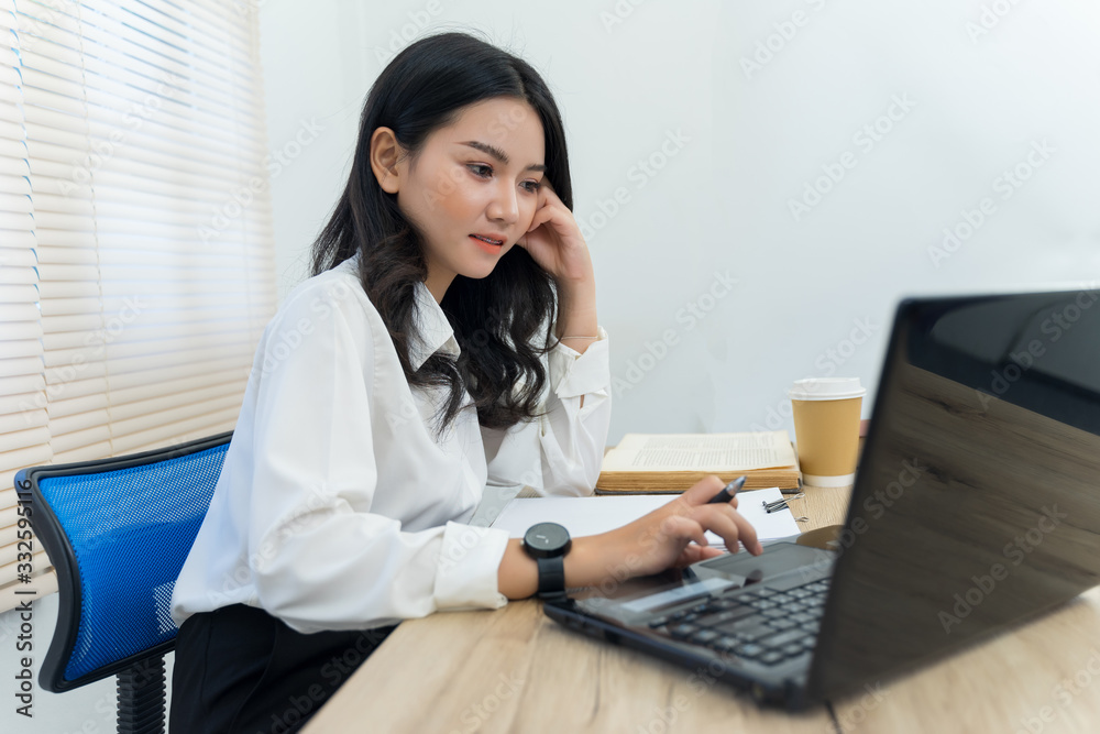 Young cheerful Asian female university student studying in self study room in the university library to do her assignment and prepare for examination. Young cheerful Asian female university student studying in self study room in the university library to do her assignment and prepare for examination.