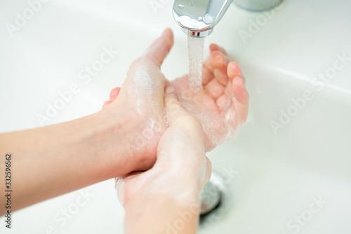 Washing of female hands with soap in bath room