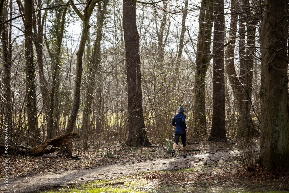 man running alone in German park at rainy day