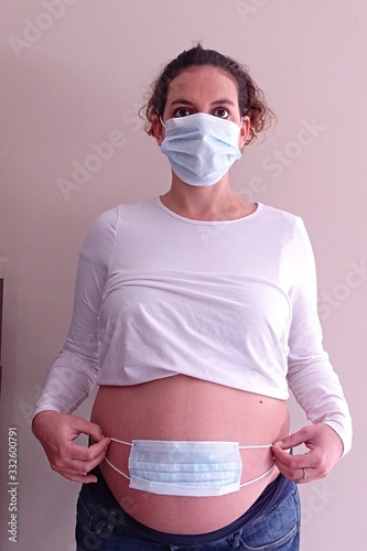 pregnant woman with medical mask on face and abdomen to prevent coronavirus. Covid 19