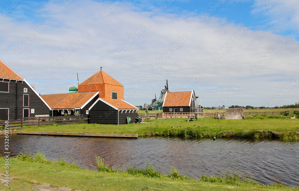 View of traditional Dutch farm houses along a canal in spring at the Zaanse Schans, Zaandam, Netherland View of traditional Dutch farm houses along a canal in spring at the Zaanse Schans, Zaandam, Netherland