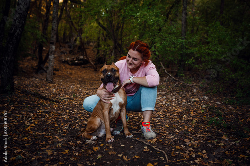 redhaired woman with her dog have fun on the walking