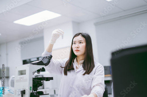 Wallpaper Mural young female medical  scientist looking at test tube in medical laboratory  Torontodigital.ca