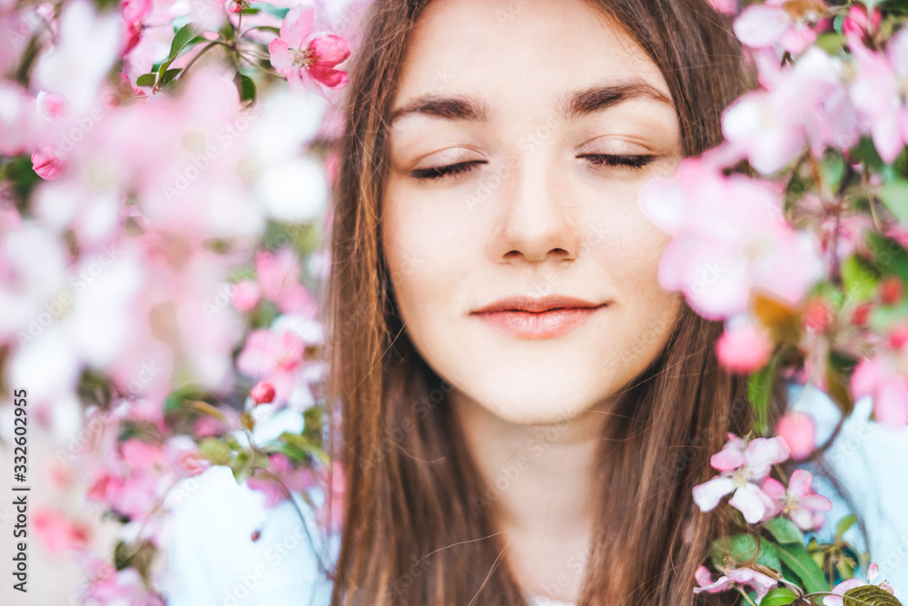 Young girl with closed eyes surrounded by flowers of a pink apple tree. Young girl with closed eyes surrounded by flowers of a pink apple tree.